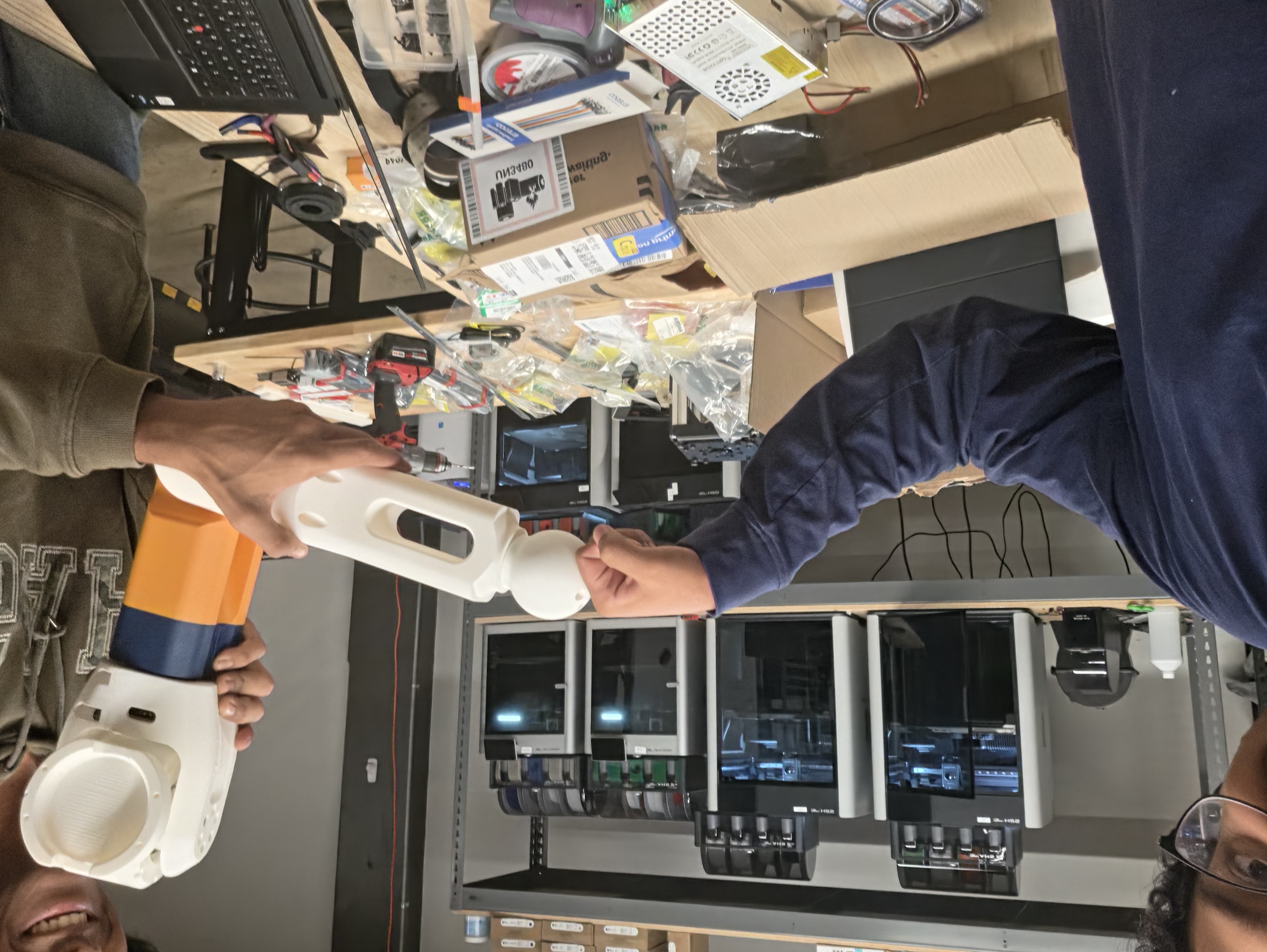 Team holding 3D-printed robot arm
